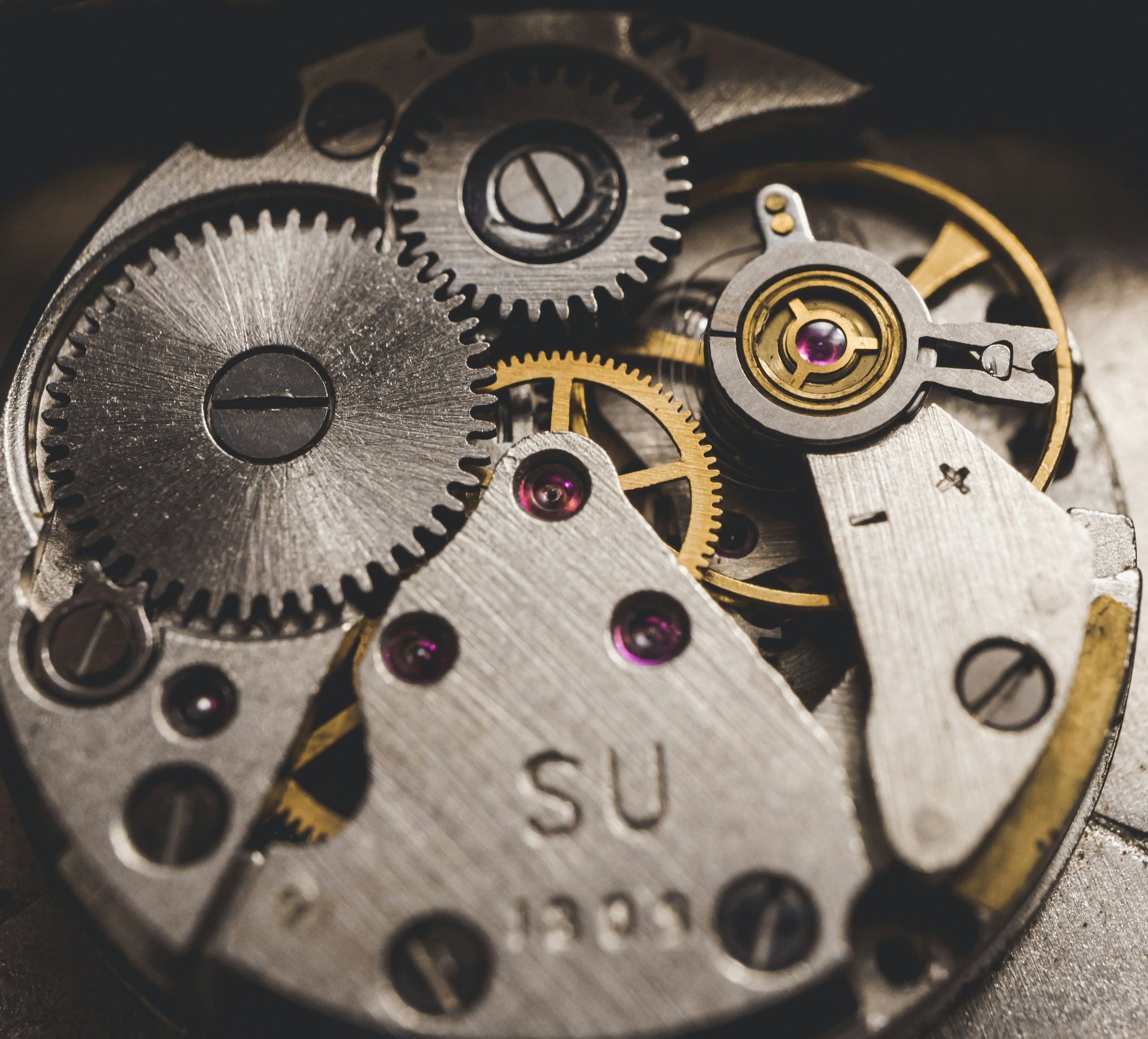 A mechanical watch movement: gear train, jewels and balance wheel under the light